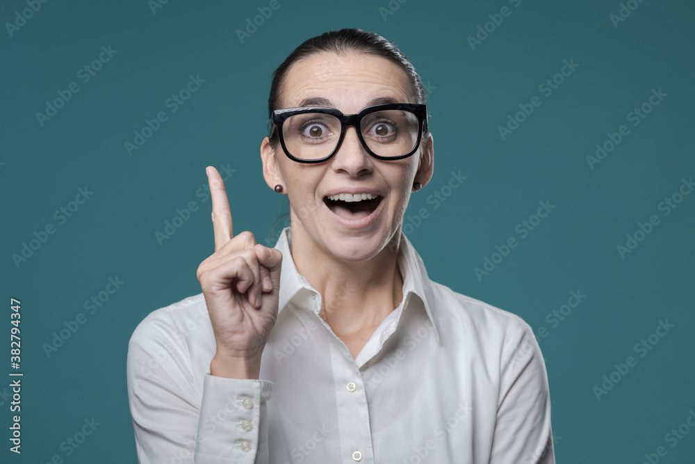Happy businesswoman pointing upwards and smiling Happy businesswoman pointing upwards and smiling