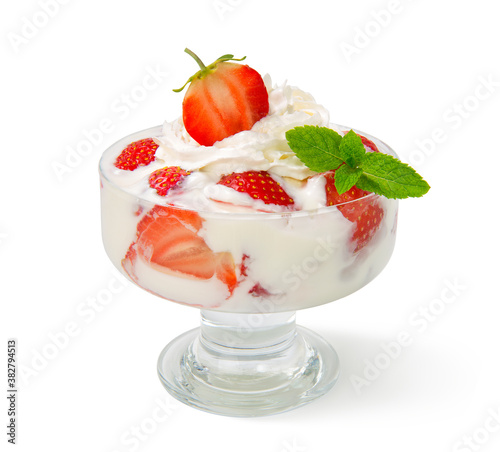 Fresh strawberries with whipped cream and a sprig of mint in a glass bowl, isolated on a white background.