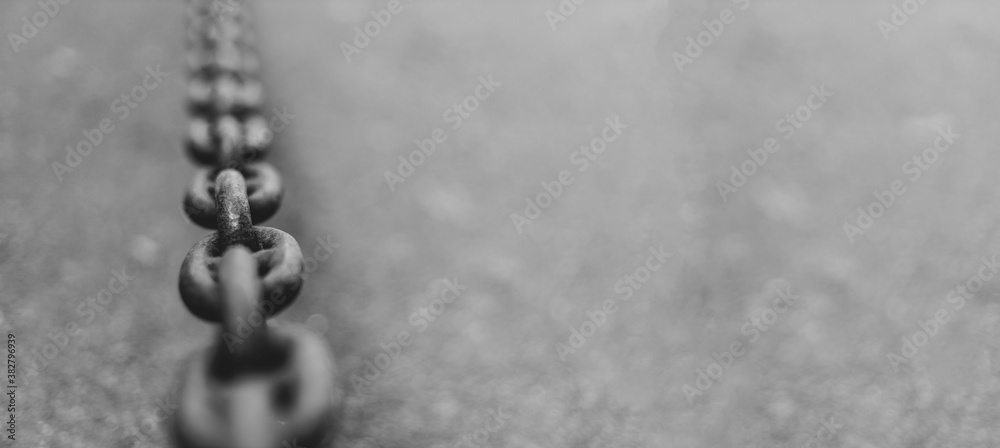 Long metal chain on asphalt background with copyspace Long metal chain on asphalt background with copyspace