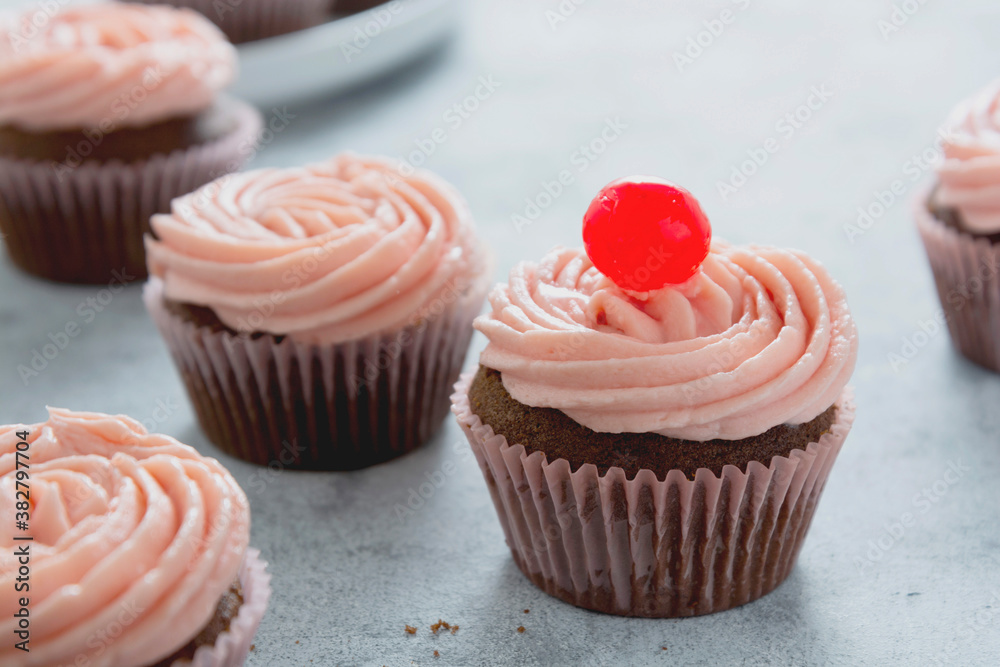 Chocolate cupcakes with strawberry buttercream, selective focus. Copy space.