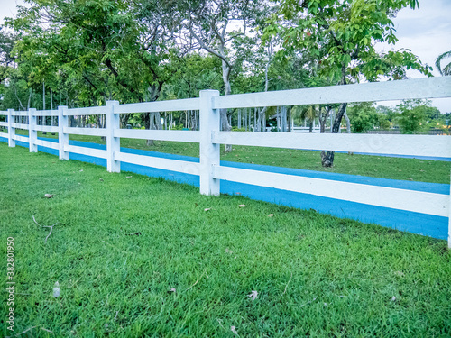 white fence with lawn in city park