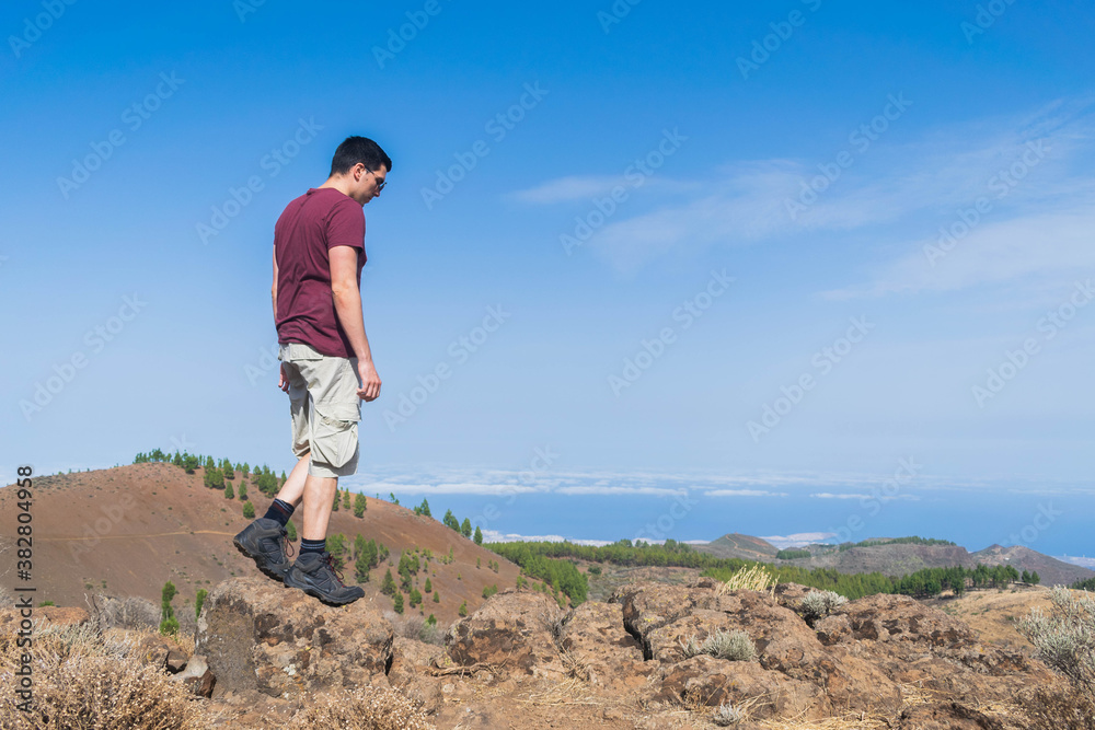 Young hiker walking between rocks