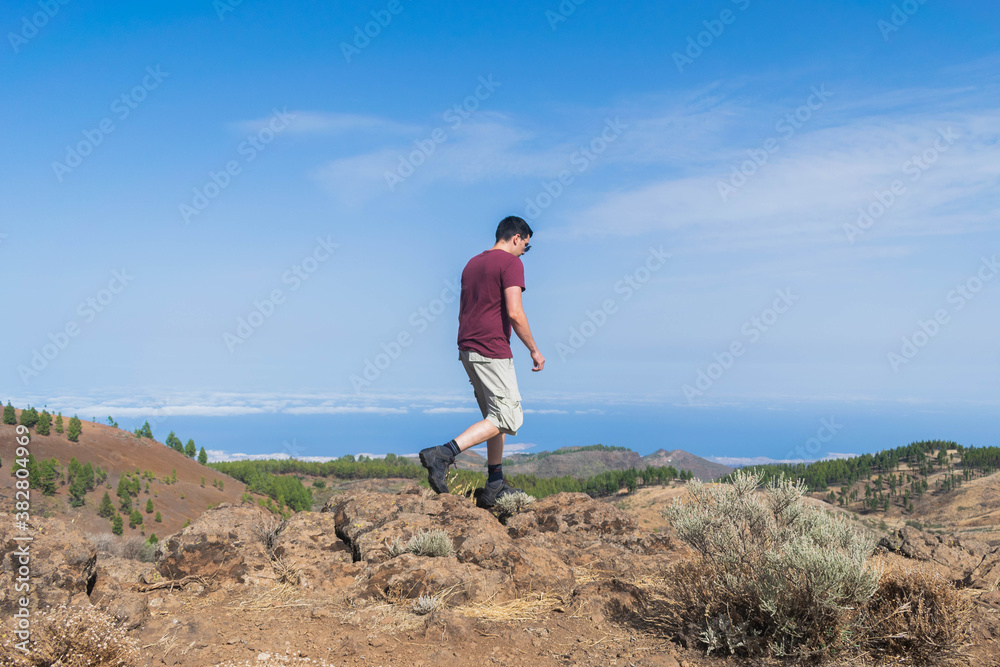 Young hiker walking between rocks