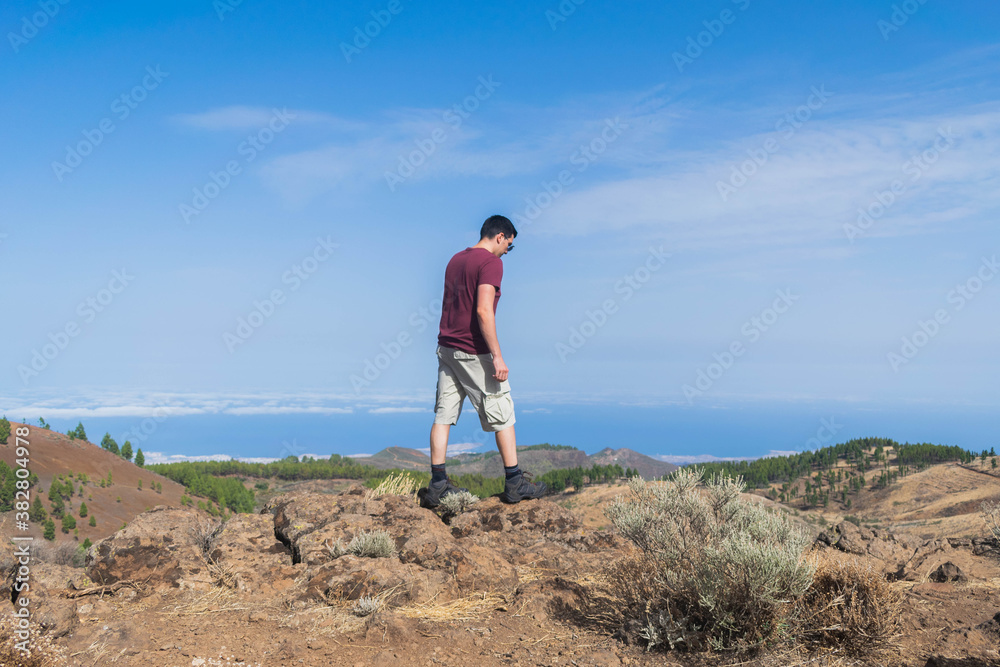 Young hiker walking between rocks