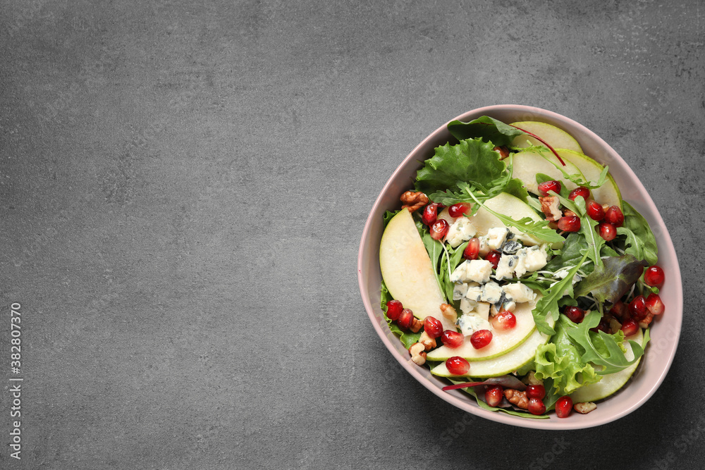 Tasty salad with pear slices and pomegranate seeds on grey table, top view. Space for text Tasty salad with pear slices and pomegranate seeds on grey table, top view. Space for text