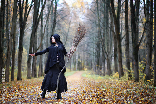 A woman in a witch suit in a forest © alexkich