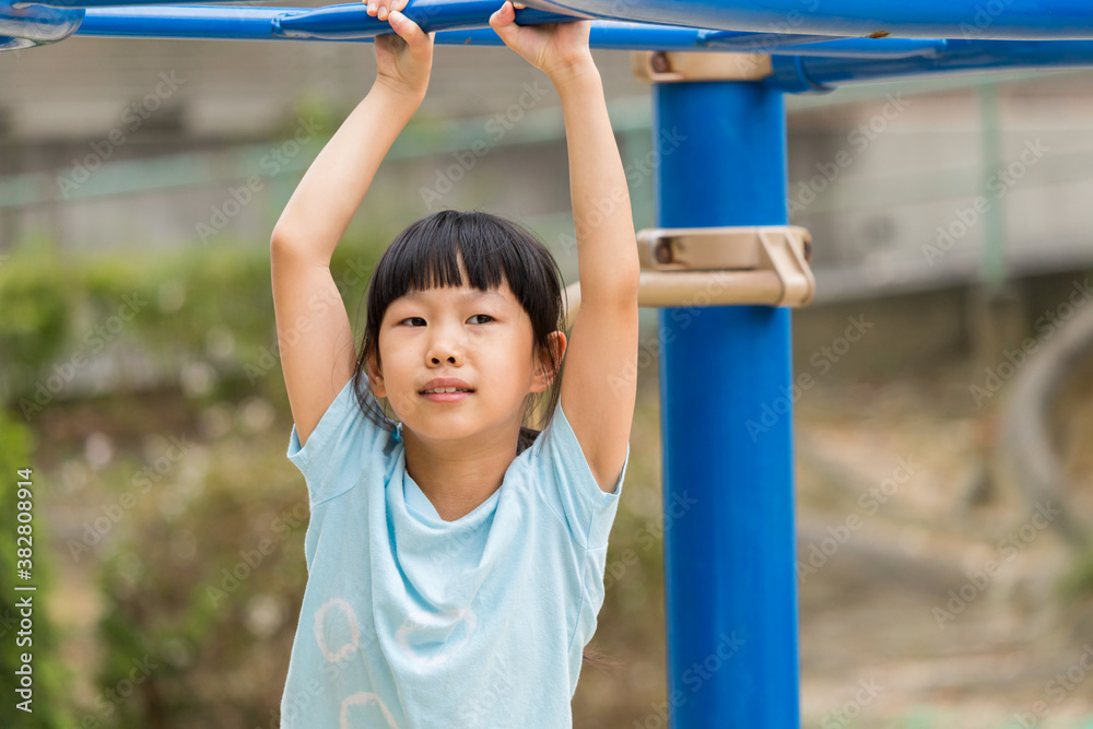 真夏の公園で雲梯遊具を遊んでいる可愛い子供 真夏の公園で雲梯遊具を遊んでいる可愛い子供