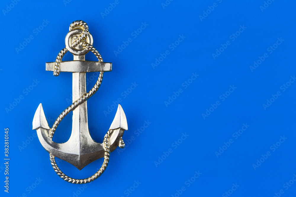 Fototapeta premium Metal anchor on a blue background