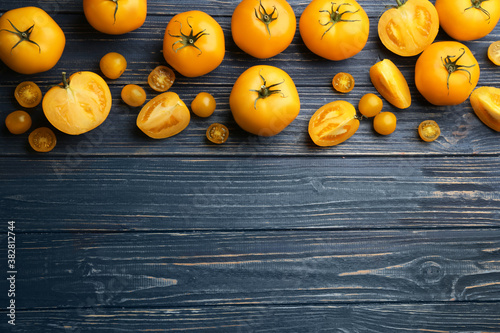 Ripe yellow tomatoes on blue wooden table, flat lay. Space for text