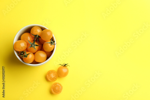 Yellow tomatoes on color background, flat lay. Space for text