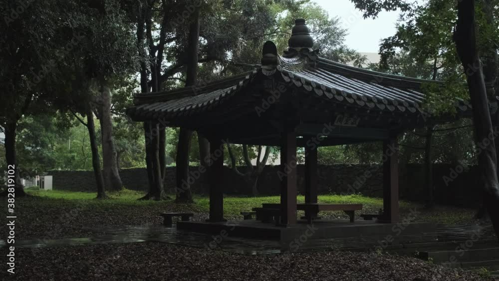 A traditional Korean pavilion in a rainy park. Text means 'House to Miss Special' A traditional Korean pavilion in a rainy park. Text means 'House to Miss Special'