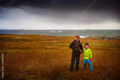 Fototapeta Naklejka Na Ścianę i Meble -  Mother and Daughter Hiking in Stormy Coastal Weather