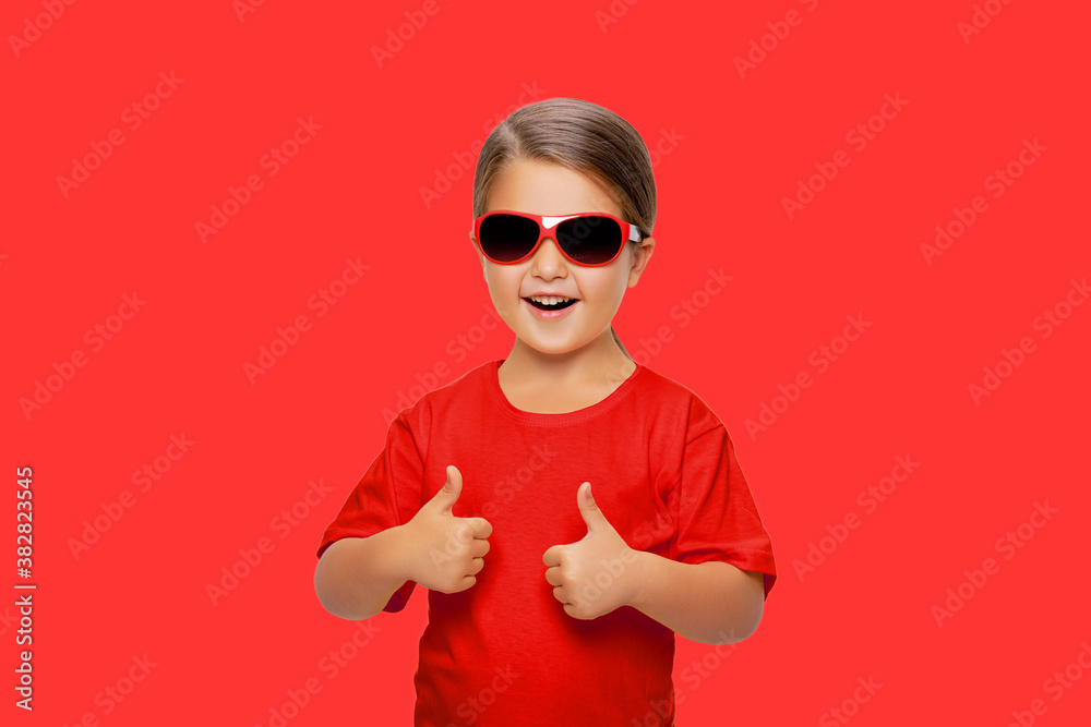 Portrait of an excited little girl showing ok sign. isolated. beautiful child in red clothes showing two thumbs up cool hand gesture Portrait of an excited little girl showing ok sign. isolated. beautiful child in red clothes showing two thumbs up cool hand gesture