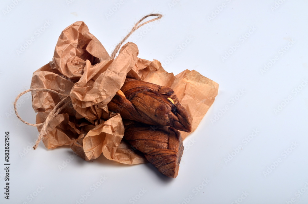 Dried melons in a paper bag, close-up, on a white background. Dried melons in a paper bag, close-up, on a white background.