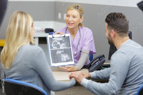 doctor showing ultrasound to couple