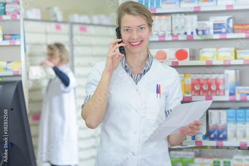 female pharmacist on phone call reaching medication