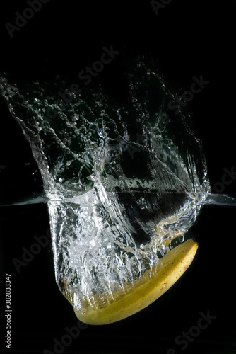 banana immersed in water, on black background