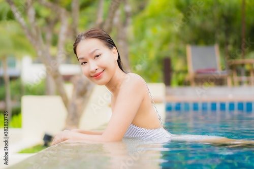 Portrait beautiful young asian woman smile relax around outdoor swimming pool in resort