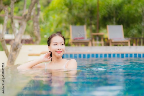 Portrait beautiful young asian woman smile relax around outdoor swimming pool in resort © siraphol
