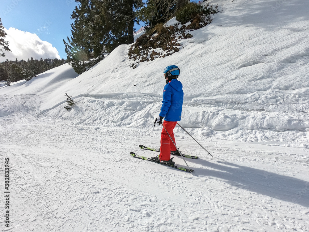  boy is skiing in sunny weather and blue sky