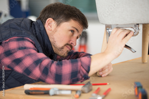 man using staple gun for crafts project
