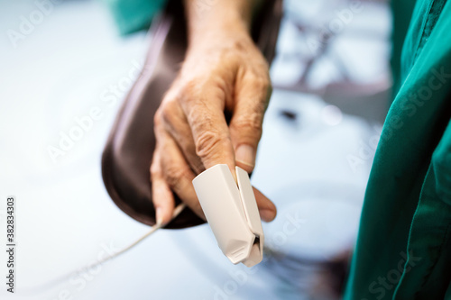 Patient with pulse oximeter on finger for monitoring during surgery