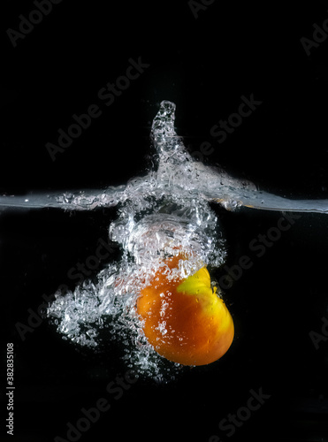 Tomato immersed in water, on black background