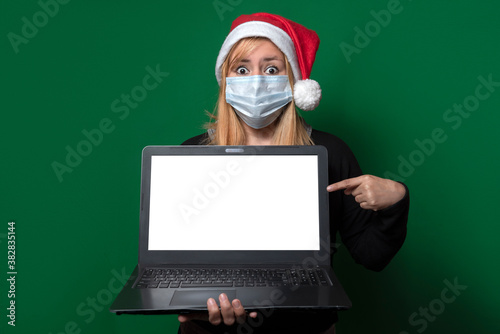 Beautiful latin woman smiles in fashion portrait holding a laptop with her hands lifestyle merry christmas happy new year holidays vacation new normal after corona virus disease covid-19