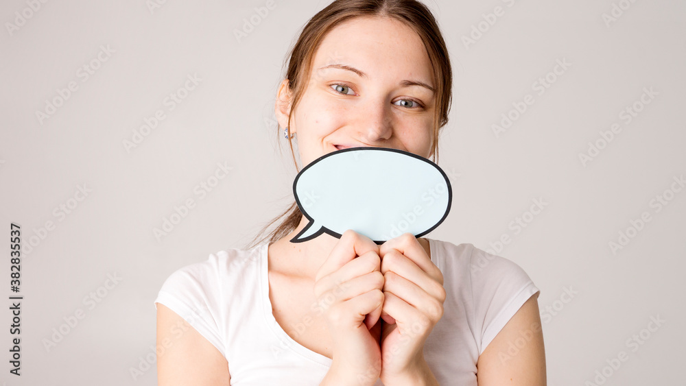 Surprised happy woman in shirt holding blank speech bubble Surprised happy woman in shirt holding blank speech bubble