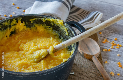 creamy polenta in a pot with wooden spoon