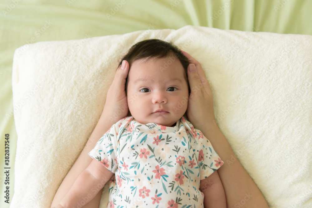 Top view of hand holding head of cute little Asian baby girl Top view of hand holding head of cute little Asian baby girl