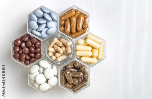 Various medical capsules and tablets in hexagonal jars