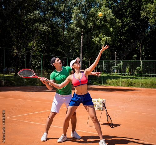Young athletic woman playing tennis with her coach. © romaset