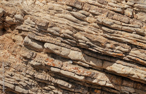 Closeup photo of pancake sedimentary rock formations on the coast.  Water pressure caused dead marine creatures and plants landed on the seabed about 2 km below the surface.to solidify into layers. © Myst