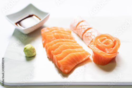 Fresh salmon and toro sashimi with shoyu and wasabi with chopsticks on mable plate. 