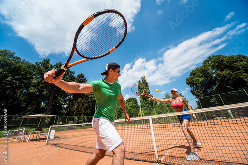 Young athletic couple playing tennis on the court. © romaset