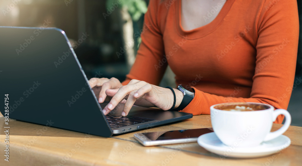 Cropped shot of young businesswoman working on her laptop while sitting outdoors at a cafe Cropped shot of young businesswoman working on her laptop while sitting outdoors at a cafe