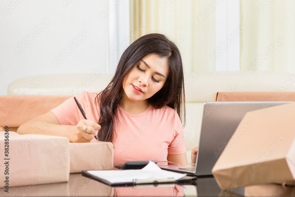 Online shop owner writing address on packages Online shop owner writing address on packages