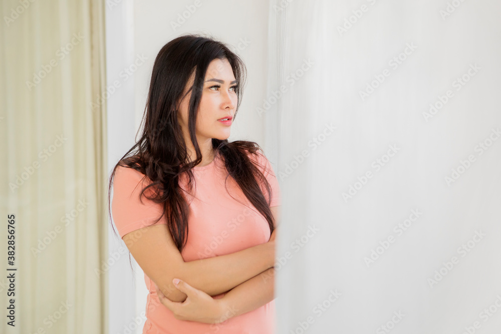 Thoughtful young woman standing near the window Thoughtful young woman standing near the window