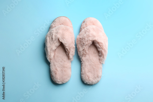 Pair of stylish soft slippers on light blue background, flat lay