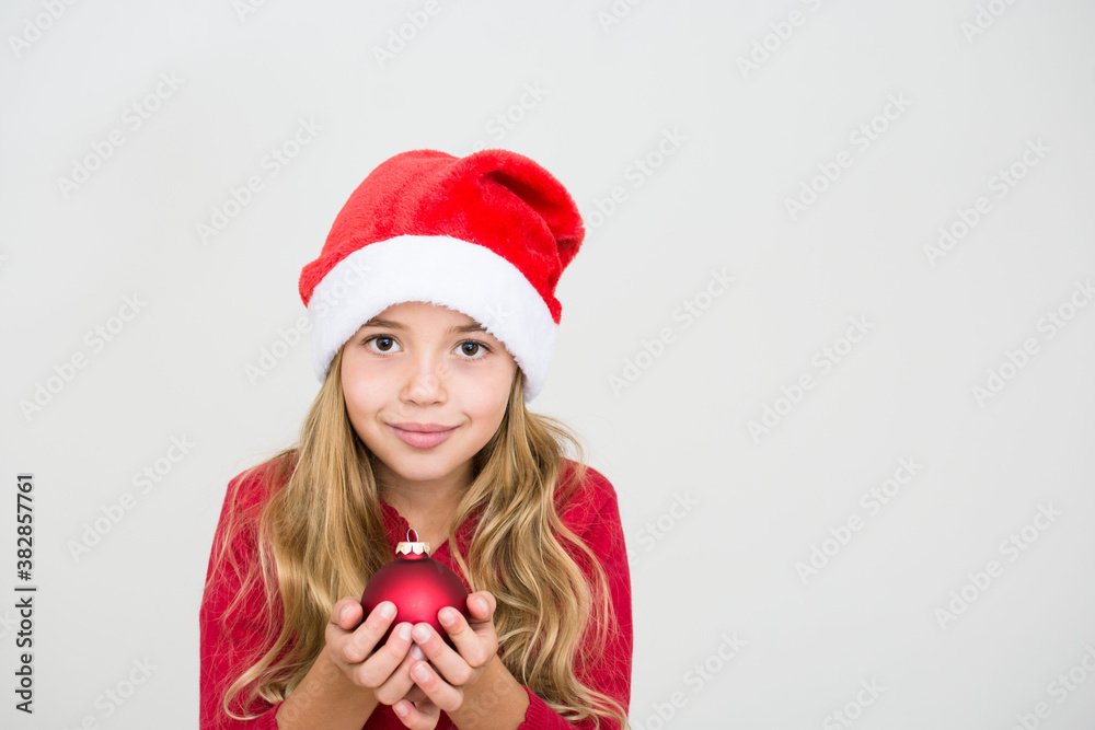 Young girl in red santa hat with christmas ball. Child with Christmas decoration, banner copy space. Isolated on white background. Young girl in red santa hat with christmas ball. Child with Christmas decoration, banner copy space. Isolated on white background.