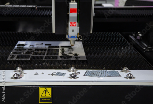 CNC fiber laser cutting machine cutting metal sheet. Industrial metalworking manufacturing