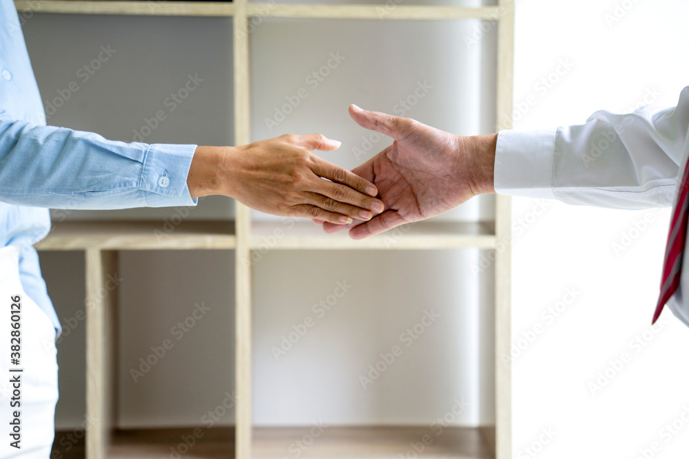 Two businessmen are shaking hands to congratulate