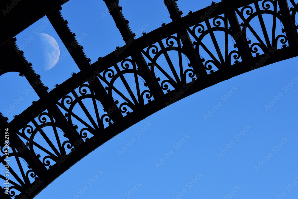 Eiffel tower arches and rising moon Eiffel tower arches and rising moon