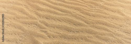 Panoramic sandy background. Sand on the beach formed by wind
