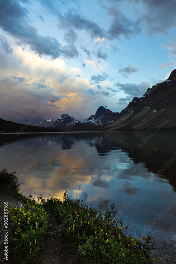 Cloud and storm reflections over Bow Lake in Alberta,, Canada along the famous Icefield Parkway. Calm yet moody scene, tranquil isolation