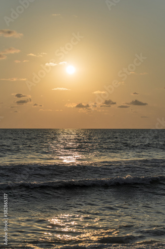 Vertical shot of an admirable sunset on a wavy sea