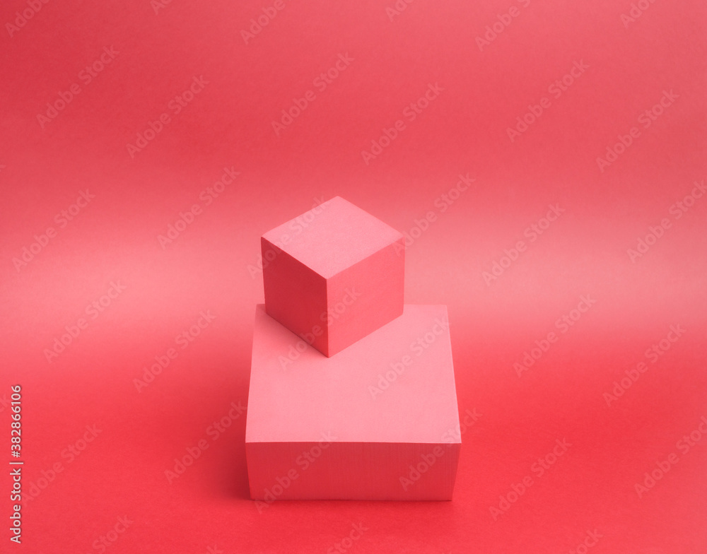 Fototapeta premium Photo of a bright podium (pedestal) of two cubes on a paper background. In pink, with gradient. Advertising place. Blank product stand and abstract background with light.