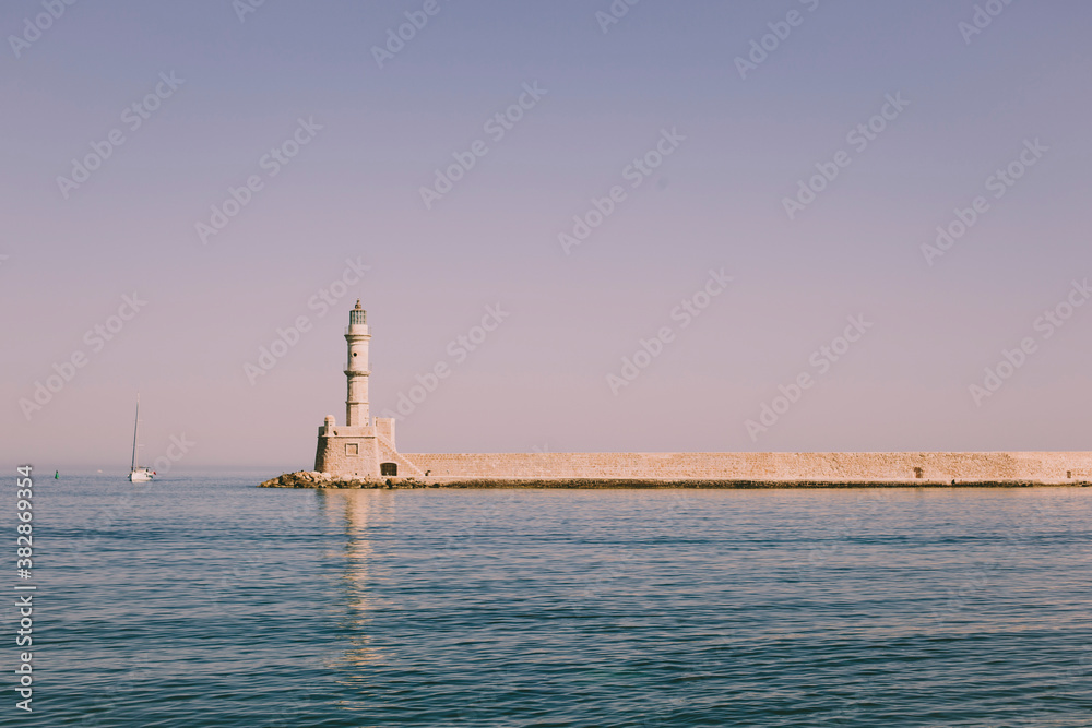 Beautiful lighthouse by the sea. Evening sunset light.  Travel romantic. Copy space. 