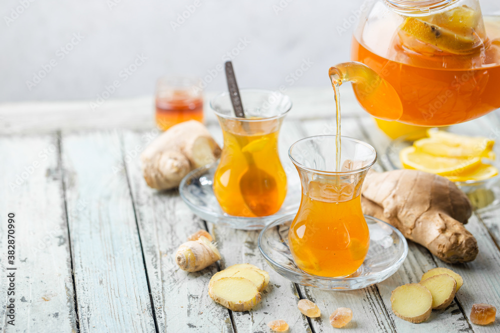 Ginger tea in a glass cup with lemon and mint on light background Ginger tea in a glass cup with lemon and mint on light background